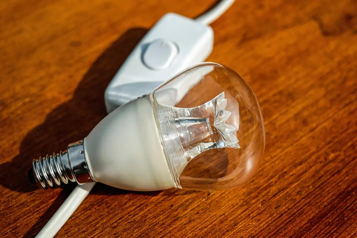 Bombilla LED con su cable y su interruptor sobre una mesa de madera